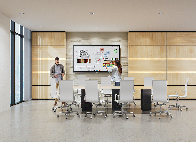 Professionals collaborating with a wall-mounted interactive display in a modern conference room
