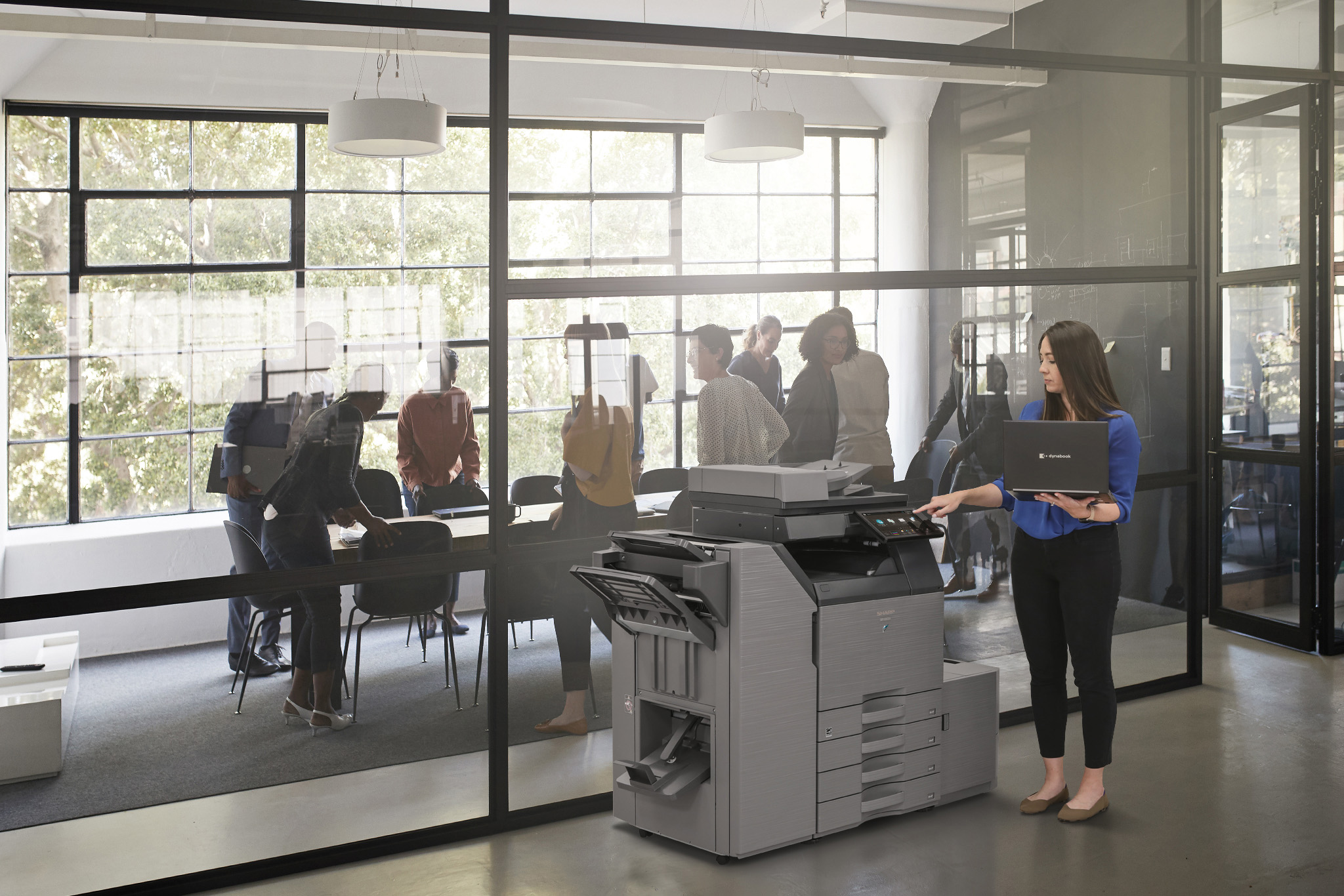 Sharp multifunction copier in a modern office with employee